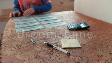 特写男孩`他的手从桌子上<strong>拿钱</strong>放在口袋里。